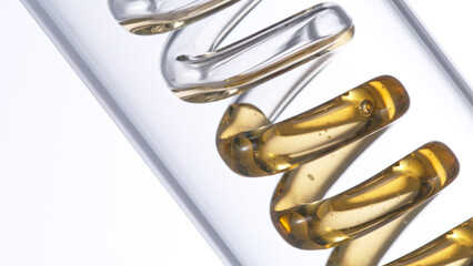 Getting natural oil from natural substances and flowers. Yellow oil flows in a spiral.