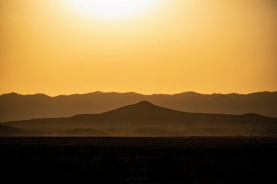 Usa, New Mexico, Santa Fe, Wildfire smoke over desert landscape at sunset