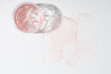 Skin care concept moisturising gel  with exfoliating particles in jar and swatch top view on ligt surface