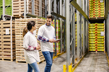 Fototapeta premium Two supervisors dispatching around the factory with tablet in hands.