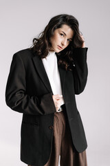 Fashion portrait of a woman with a model look without emotions. Stylish image of a young businesswoman, director or manager, creative woman dressed in stylish office clothes, pants and jacket