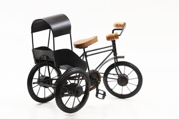 Fototapeta na wymiar Decorative souvenir bike. Antique tricycle-carriage. Shallow depth of field