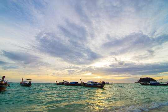 Sunset sea wave beach with wooden fishery boat