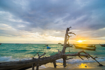 Sunset sea wave beach with wooden fishery boat