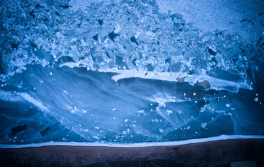 Aerial top view from above of frozen sea glaciers at the beach. Cracked ice floes in ocean on...