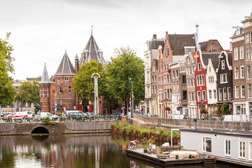 Naklejka premium rincón de la ciudad europea de amsterdam con canal, casas flotantes, barcos, iglesia y edificios, holanda , países bajos