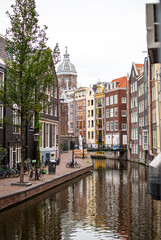curva de un canal bordeado por edificios altos y estrechos de ladrillos de colores en la ciudad de amsterdam, holanda, países bajos