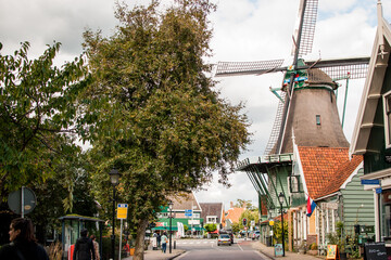 Molino de viento tradicional en pueblo turístico holandés, junto al rió Zaan en países bajos,...