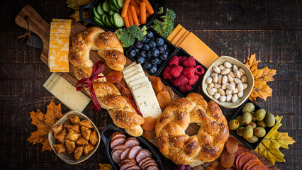 Charcuterie board, holiday, festive, entertaining, gathering, family, bread braided, fresh organic fruits and vegetables, cheeses, nuts, wooden background