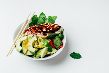 close up of a salad with meat vegetables and fruits seasoned with sauce on a beige background with free space for text