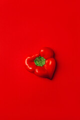 .top view of sweet pepper in the form of a heart on a red background