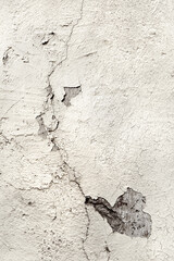 White painted cracked plastered wall with cracks. Old distressed damage surface. High resolution background image element with copy space, text place. Top view, flat lay, textured surface.