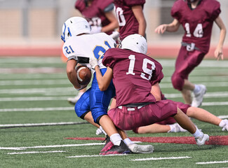 Young athletic tackle football players making great plays during a game