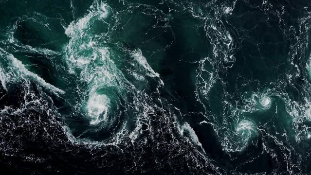 4K drone video with birds-eye view of the abstract and powerful water currents, rapids and whirlpools of the worlds larges maelstrom Saltstraumen, Norway.