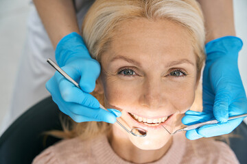 Smiling woman visiting dental cabinet for procedure