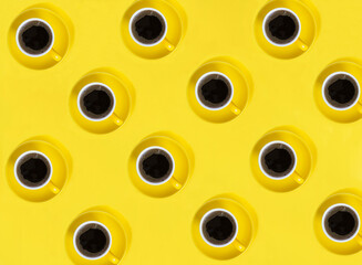 Fototapeta premium Top view of yellow coffee cups on the yellow background. Pattern. Flay lay.