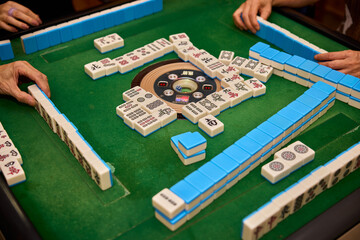 Elderly people playing mahjong, indoor gamble activity at home during spring festival.