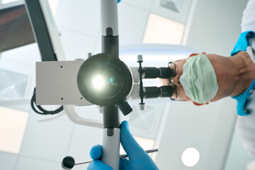Professinal dentist using dental microscope for examination