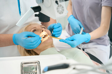 Female person lying on the dental coach with open mouth