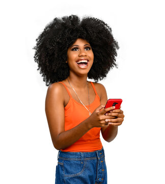 positively surprised young woman points to a white space, holds a smart phone in one hand, black power afro style hair