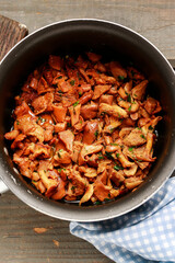 Cantharellus cibarius, commonly known as the chanterelle, golden chanterelle or girolle. Mushrooms with butter in a big pot.