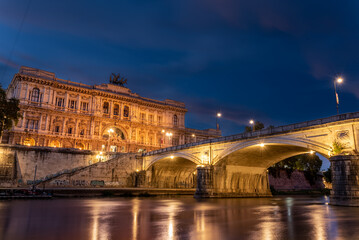 Long Exposition of the Building of the Court of Cassation and a Bridge of the Tevere River Illuminated by Lights at the Blue Hour in the Center of Rome - obrazy, fototapety, plakaty