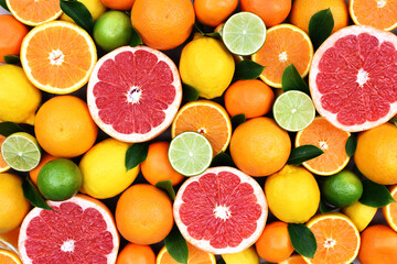 Colorful bright background of fresh ripe sweet citrus fruits: orange and tangerine, green lime and yellow lemon