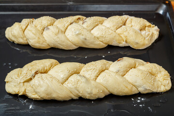 The woven challahs are ready for baking on a greased baking sheet.