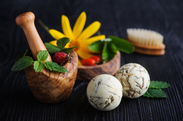 Fresh herbs in wooden mortar and bath bombs