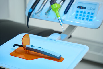 Photopolymer lamp on plastic stand on dental chair with burs