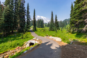 Summer landscape in mountains. Narrow trail high in the mountains. Amazing view at the snowy peaks which rose against the blue sky. MOUNT FREMONT LOOKOUT TRAIL, Sunrise Area, Mount Rainier