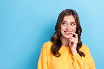 Fototapeta premium Photo portrait of adorable young woman bite nail look tricky empty space dressed stylish yellow outfit isolated on blue color background