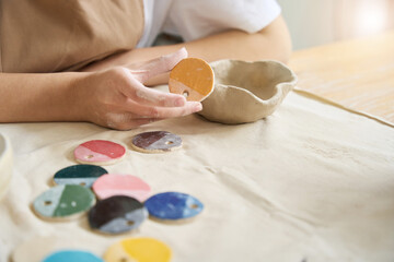 Woman holds sample palette paint for clay products in her hands