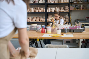 Fototapeta premium Two women work in an art workshop with clay