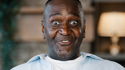 Close up surprised male portrait amazed face American African adult man 60s senior businessman...