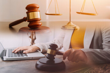 Justice and law concept.Male judge in a courtroom with the gavel, working with, computer and...