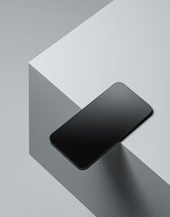 Black smartphone on grey cubes in studio.