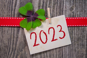 Wooden hang tag and slate with four leaf clover and sparklers with the german words for happy new...