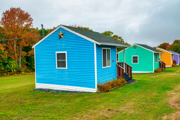 Fototapeta na wymiar Colorful wooden homes in a foliage landscape, autumn season