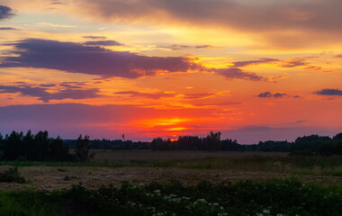 Landscape with sunset in the village in summer