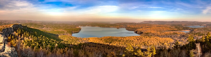 Panoramic view from the mountain to the lakes, forest against the blue sky in autumn