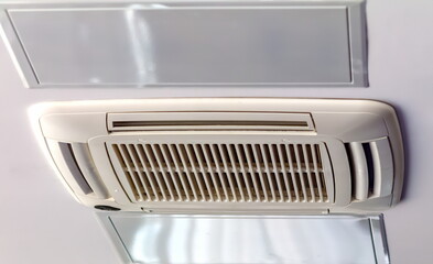 Air conditioner grille in close-up on the background of the office ceiling