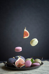 Macaron cake, ripe sweet figs on a dark background. Falling macron, fig.