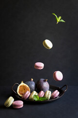 Macaron cake, ripe sweet figs on a dark background. Falling macron, fig.