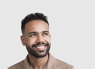 Obraz premium Closeup portrait of handsome smiling young man. Laughing joyful man looking up. Studio shot isolated on gray background