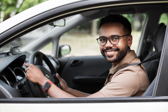 Smiling young man driving a car. Behind the wheel, transportation, car rental, credit, buying a car, modern lifestyle, business concept