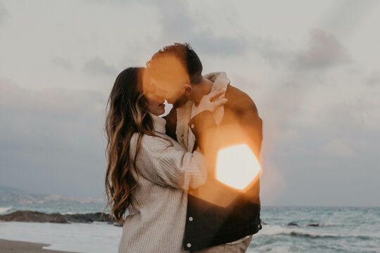 Pareja de enamorados disfrutando del atardecer en la playa