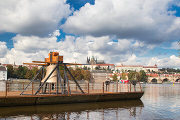 The Commemorative bell #9801 on a pontoon in the Vltava river at Smetanovo nábřeží. Prague. Prague Castle and Charles bridge in behind.