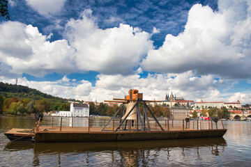 The Commemorative bell #9801 on a pontoon in the Vltava river at Smetanovo nábřeží. Prague. Prague Castle and Charles bridge in behind.	