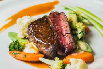 Grilled steak is served with vegetable sauce. steak, salt, ground black pepper, coriander, vegetable oil, olive oil, tomatoes, lemon juice, basil, capers, lemon, salt, ground black pepper.